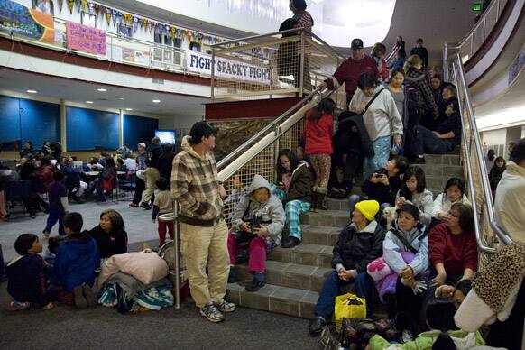 People gather at Sitka High School in Alaska, following a magnitude 7.5 earthquake and after a subsequent tsunami warning was declared for hundreds of miles of Alaskan and Canadian coastline.