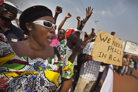 Several hundred protesting merchants, one holding a placard using the french acronym of the country`s name, hold a demonstration calling for peace as negotiators prepare for talks with rebels from the north, in downtown Bangui, Central African Republic.