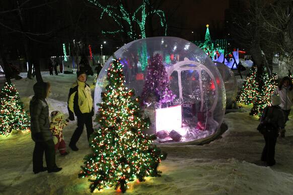 People walk past world renowned American light designer Richard Holdman`s unique light show in Moscow.