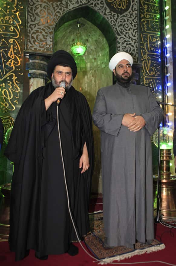 Firebrand Shiite cleric Muqtada al-Sadr, left, address worshippers as a Sunni cleric Anas al-Issawi, right, listen during the Friday prayers at Abdul-Qadir al-Gailani Sunni mosque in Baghdad, Iraq.
