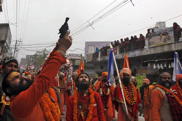 A Naga Sadhu fires in the air during a religious procession towards the Sangam, the confluence of rivers Ganges, Yamuna and mythical Saraswati, as part of the Mahakumbh festival in Allahabad.
