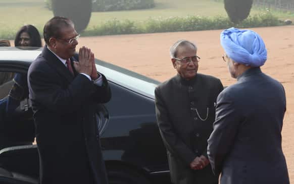 Mauritian President Rajkeswur Purryag, left, gestures to President of India Pranab Mukherjee, center, and Prime Minister Manmohan Singh, on his arrival in New Delhi