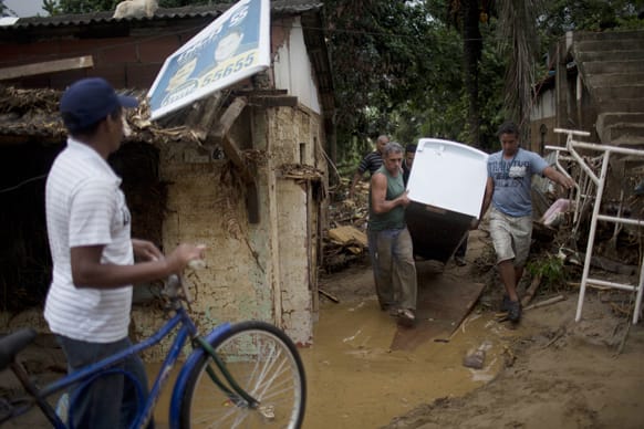 Residents salvage a fridge from a home flooded by heavy rains in the Xerem neighborhood, about 31 miles north of Rio de Janeiro, Brazil.