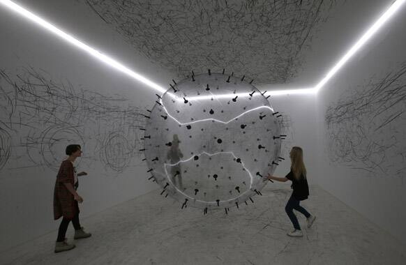 Visitors look at an exhibit on display during the opening of