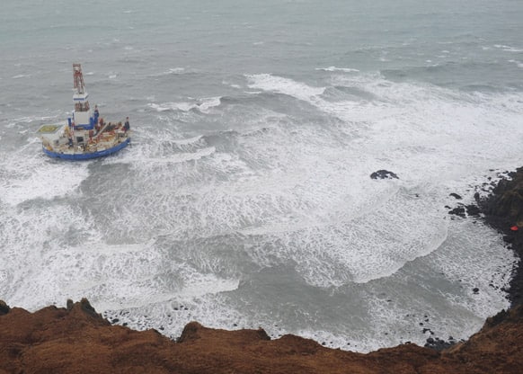 This aerial image provided by the U.S. Coast Guard shows the Royal Dutch Shell drilling rig Kulluk aground off a small island near Kodiak Island.