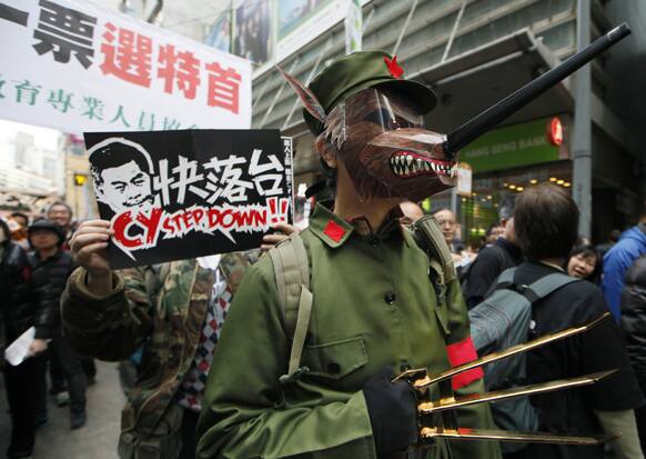 A protester dressed as a Chinese Red Guard with a wolf mask, representing Hong Kong`s Chief Executive Leung Chun-ying, participates in an anti-government march on New Year`s Day in Hong Kong.
