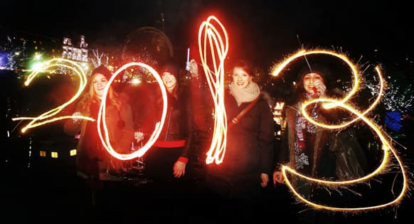 Katy Saunders, left, Alex Mueller, center left, Rebekka Frank and Arina Motamedi, right, play with sparklers ahead of welcoming in the new year during the 2013 Edinburgh Hogmanay celebrations, Scotland.