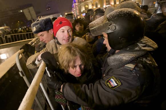 Russian police officers push protesters off Triumphalnaya square during an unsanctioned rally in downtown Moscow, Russia.