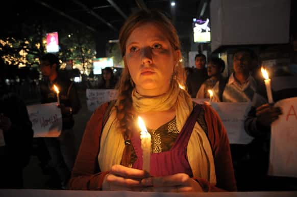 A British tourist join others in a candlelight vigil to mourn the death of a gang rape victim, in Kolkata.