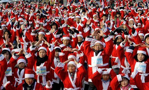 South Korean runners wearing Santa Claus costumes do exercise before taking part in the Santa Marathon race in Seoul, South Korea