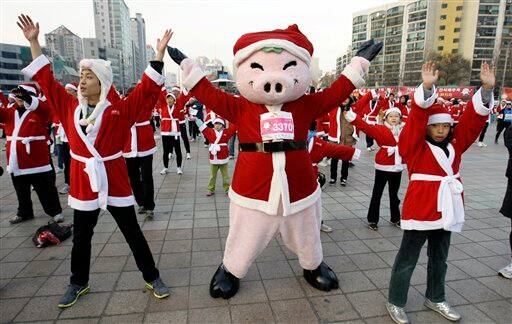 South Korean runners wearing Santa Claus costumes do exercise before taking part in the Santa Marathon race in Seoul, South Korea