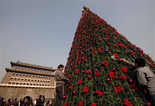 Workers decorate a Christmas tree displayed at the Qianmen street in Beijing, China