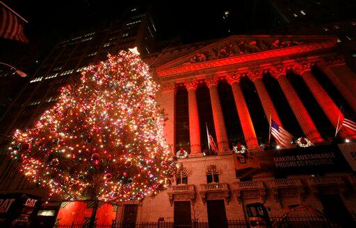 A Christmas tree lights up Wall Street in front of the New York Stock Exchange