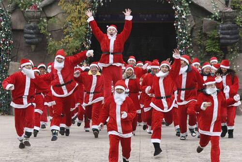 Employees dressed in Santa Claus costumes run towards cameras during a photo opportunity at the Dream Valley theme park in Hengdian, Zhejiang province.