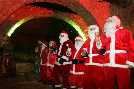 Jordanians dressed as Santa Claus gather to celebrate the lighting of the 26-meter tree, alleged to be the largest Christmas tree in the Middle East, in the Christian town of Fuheis,  Jordon.