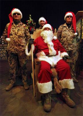 German Bundeswehr army soldiers of the International Security Assistance Force (ISAF) are dressed as Santa Claus as they attend a Christmas tombola at Camp Marmal in Mazar-e-Sharif, north of Kabul.