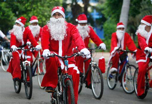 Employees dressed in Santa Claus costumes ride bicycles during a Christmas celebration at Ancol theme park in Jakarta, Indonesia.