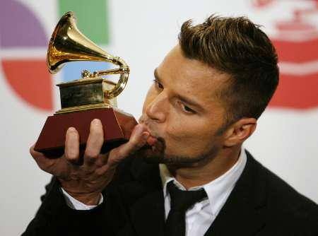 Ricky Martin kisses one of his Grammy awards after winning the Latin Grammy for best male pop vocal album for 