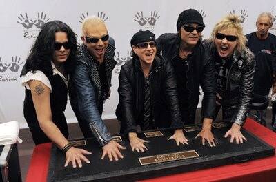 The German rock band The Scorpions, from left, Pawel Maciwoda, Rudolf Schenker, Klaus Meine, Matthias Jabs and James Kottak put their hands in cement as they are inducted into the Hollywood Rockwalk i