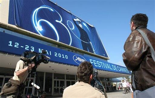 Television cameramen film the set up of a giant canvas of the 63rd Cannes Film Festival's official poster on the Cannes Festival Palace