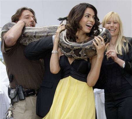 Actress Mallika Sherawat, center, poses with a snake during a photo call for 