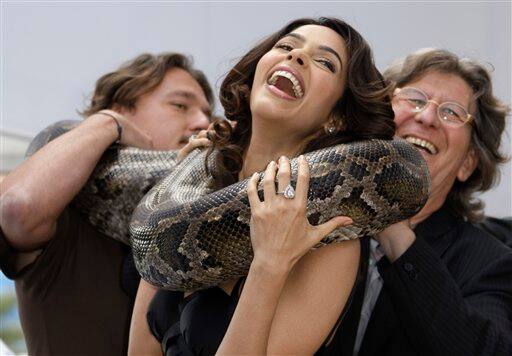 Actress Mallika Sherawat, center, poses with a snake during a photo call for 