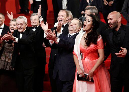 Cast and crew of Des Hommes Et Des Dieux, from left, actor Jacques Herlin, actor Philippe Laudenbach, an unidentified guest, actress Sabrina Quazani and actor Farid Larbi exit before for the screening of the film 