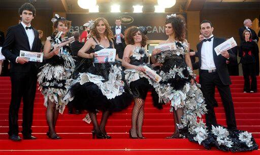 Employees of local French daily newspaper Nice Matin wear dresses partially made of the newspaper in protest at management policy, as they arrive for the screening of 