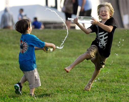 Hunter Goll, 3, of Pequannock, N.J. gets in a water fight with his older brother Elijah Goll, 7, right,, during the Summer Camp Music Festival at Three Sisters Park in Chillicothe.