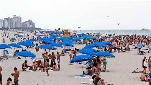 Tourists and local residents enjoy a day the the beach as Memorial weekend begins in the South Beach area of Miami.