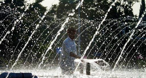 A Pakistani worker fixes a fountain during a hot day in Islamabad, Pakistan.