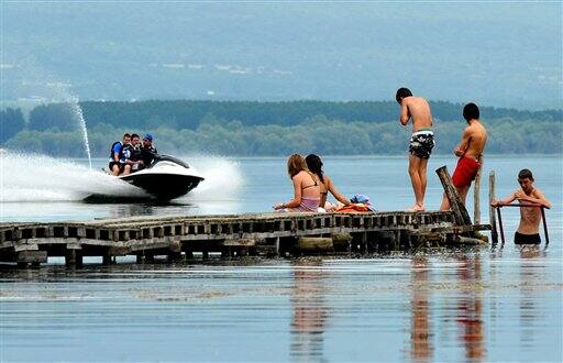 A jet ski passes a group of teenagers in Dojran Lake, southeastern Macedonia, as the temperature reaches over 30 degrees celsius.