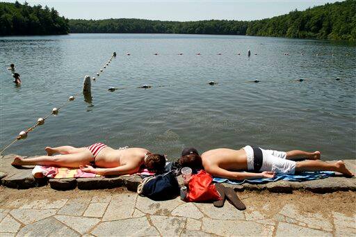 Katie Pekkuala and Jake Hebert both of Maynard, Mass., lie on the edge of Walden Pond, in Concord, Mass.