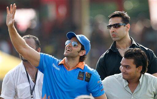 Bollywood actor Hrthik Roshan, in blue, waves to fans along with Sri Lankan presidents son and lawmaker Namal Rajapaksa during a charity cricket match between IFFA XI and Sangakkara's XI as part of the three-day long International Indian Film Academy (IIFA) awards in Colombo, Sri Lanka.