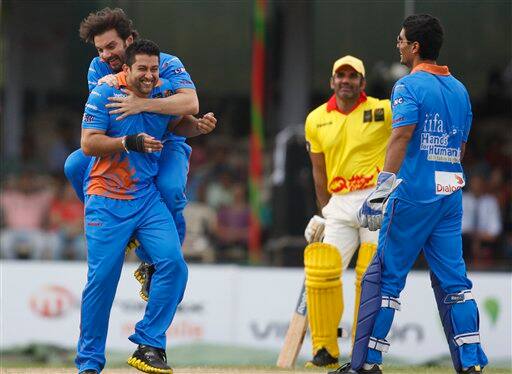 Bollywood actors Sohail Khan hugs his bowler Aftab Shivadasani, front left, for taking a wicket, as Sunil Shetty, in yellow, looks on during a charity cricket match between IFFA XI and Sangakkara's XI as part of the three-day International Indian Film Academy (IIFA) awards in Colombo, Sri Lanka, 