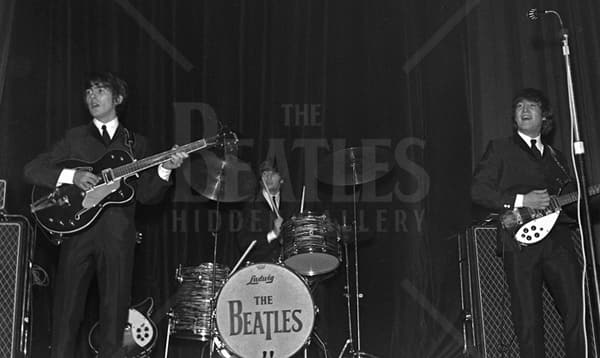 George & John flank a Ringo, sat behind his drum kit; the bass drum is adorned with their recently revealed ‘drop T’ logo.