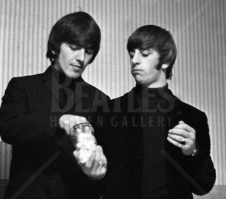 Pop Stars - George takes a piece of popcorn from the packet offered to him by Ringo.