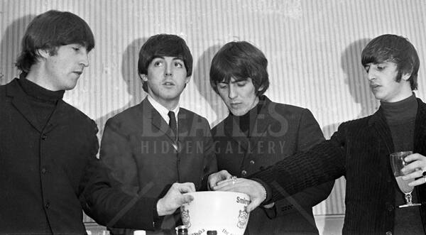 Paul looks skywards, while other members of the band appear to be reaching into an ice bucket.