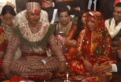 Bollywood actress Manisha Koirala, right, and groom Samrat Dahal smile as priests perform rituals at a resort, just outside Katmandu, Nepal, Saturday, June 19, 2010. Koirala married Nepalese businessman Dahal in a traditional ceremony attended by family and close friends.