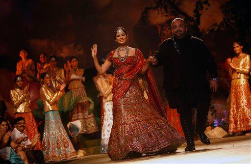 Bollywood actor Kangana Ranaut, center, walks down the ramp holding hands with Indian designer J J Valaya in the designer's creations at the Pearls Infrastructure Delhi Couture Week 2010 in New Delhi, India.