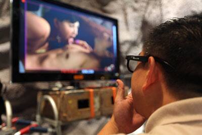 Director Christopher Sun wears 3D glasses as he watches a take on a preview screen during filming on the set of '3-D Sex and Zen: Extreme Ecstacy' in Hong Kong.