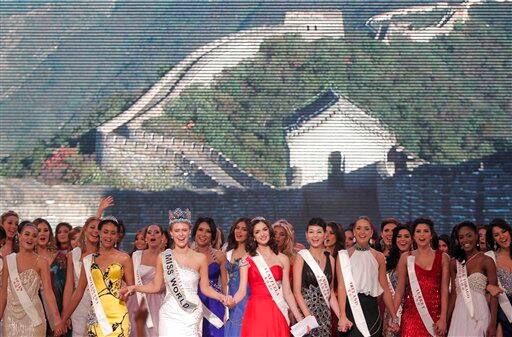 Alexandria Mills of U.S.A., third from left, sings with other contestants after after she was crowned 2010 Miss World in front of a screen showing the Great Wall at the Beauty Crown Cultural Center in Sanya.