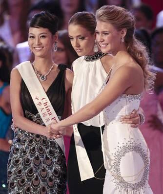 Miss USA Alexandria Mills, right, Miss Ireland Emma Waldron, center, and Miss China Tang Xiao, left, hold hands while waiting for the announcement of the winner of the 2010 Miss World pageant contest at the Beauty Crown Cultural Center in Sanya.