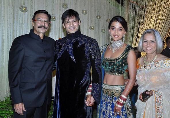 Indian Bollywood actor Suresh Oberoi (L), his son and Bollywood actor Vivek Oberoi (2L) pose with recently married Priyanka Alva (2R) and Mrs. Oberoi at their reception party in Mumbai.