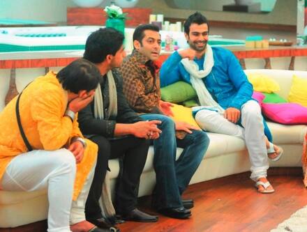 Men dressed in traditional attire sit together and bond with the host. 