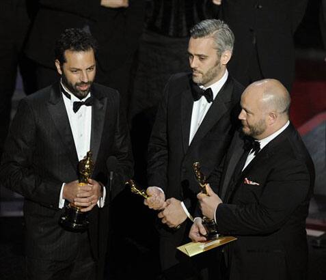 Iain Canning is flanked by Emile Sherman, left, and Gareth Unwin as they accept the Oscar for best motion picture for 