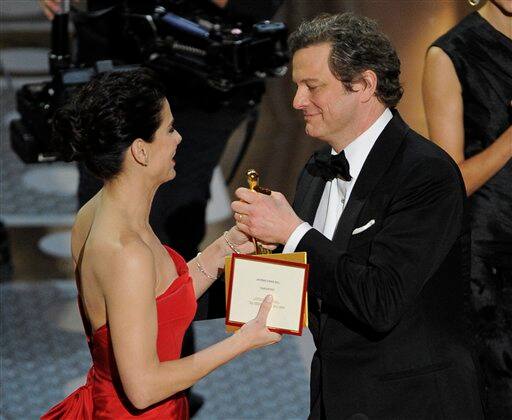 Sandra Bullock congratulates Colin Firth as he accepts the Oscar for best performance by an actor in a leading role for 