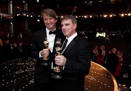 Tom Hooper and Robert Stromberg pose for a photo with the Oscar for best achievement in directing for 