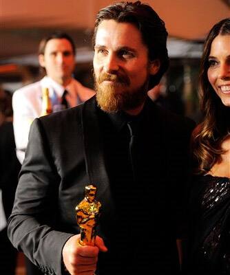 Actor Christian Bale holds his oscar for best supporting actor while attending the Governors Ball with his wife Sibi Blazic following the 83rd Academy Awards.