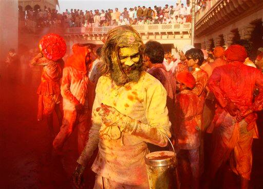 Indian villagers smear themselves with colors as they celebrate Holi festival in Nandgaon, near Mathura.